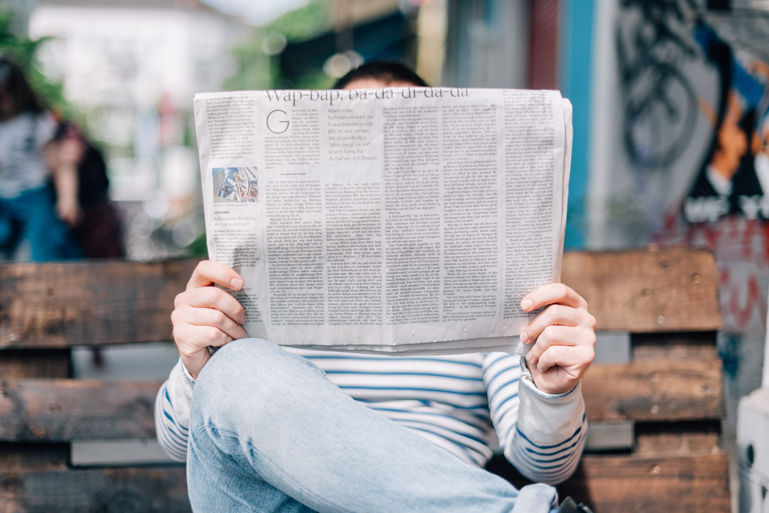 Fotografia di un uomo seduto che legge il giornale