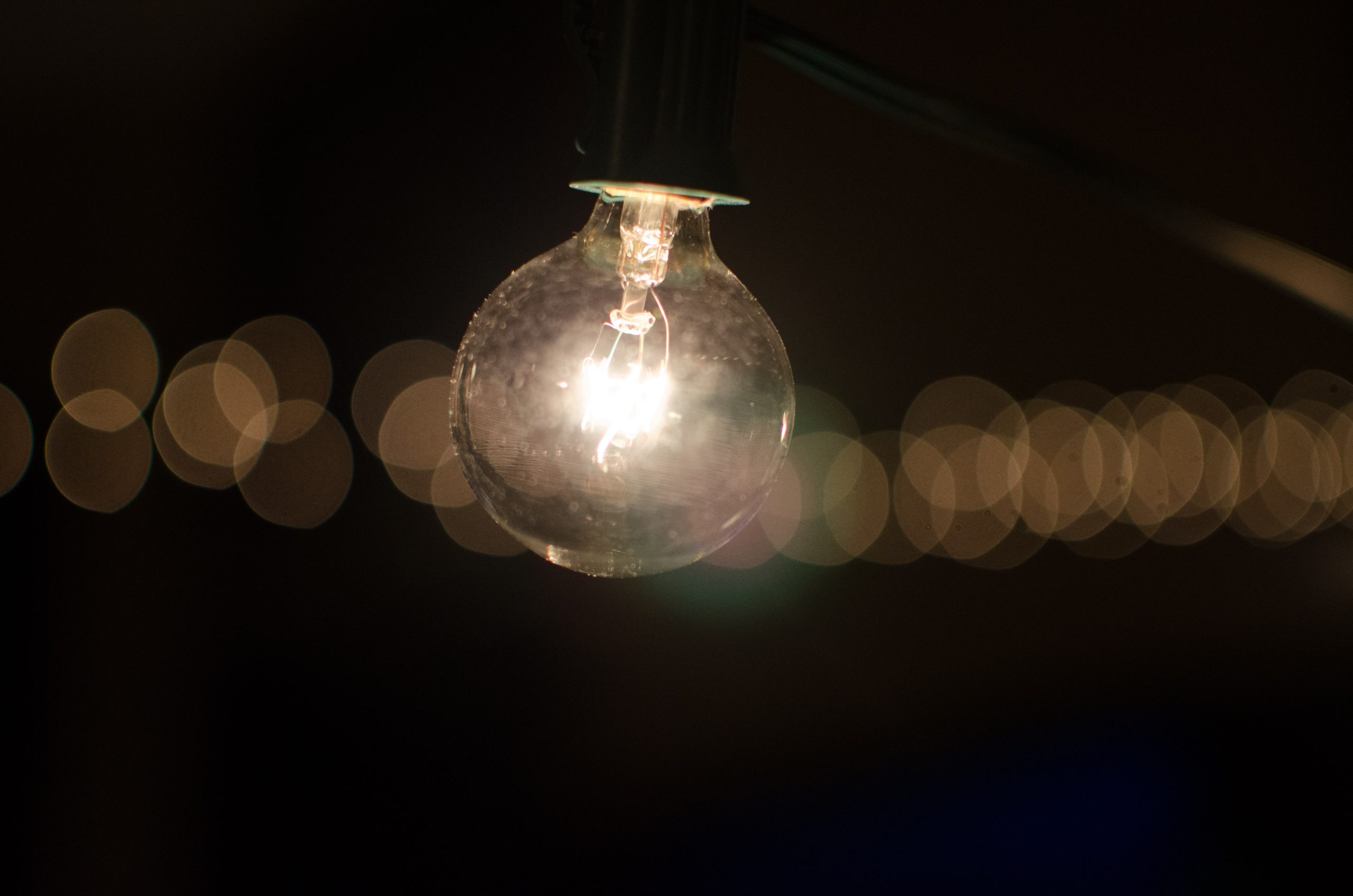 Fotografia di una lampadina accesa in un contesto di buio