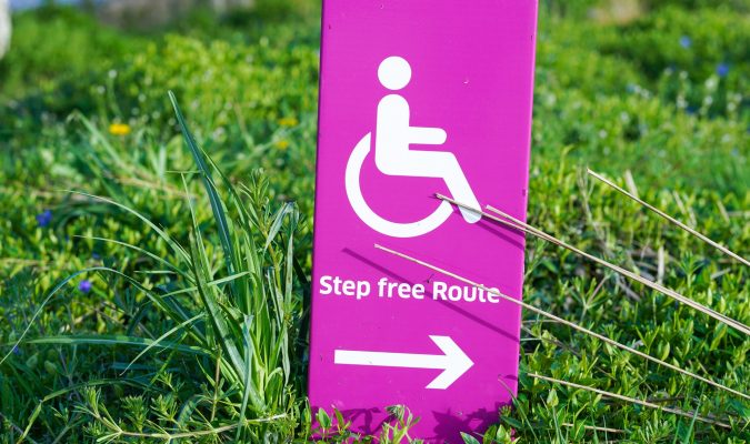 photograph of a sign with the symbol of wheelchair andth the words "step-free route"