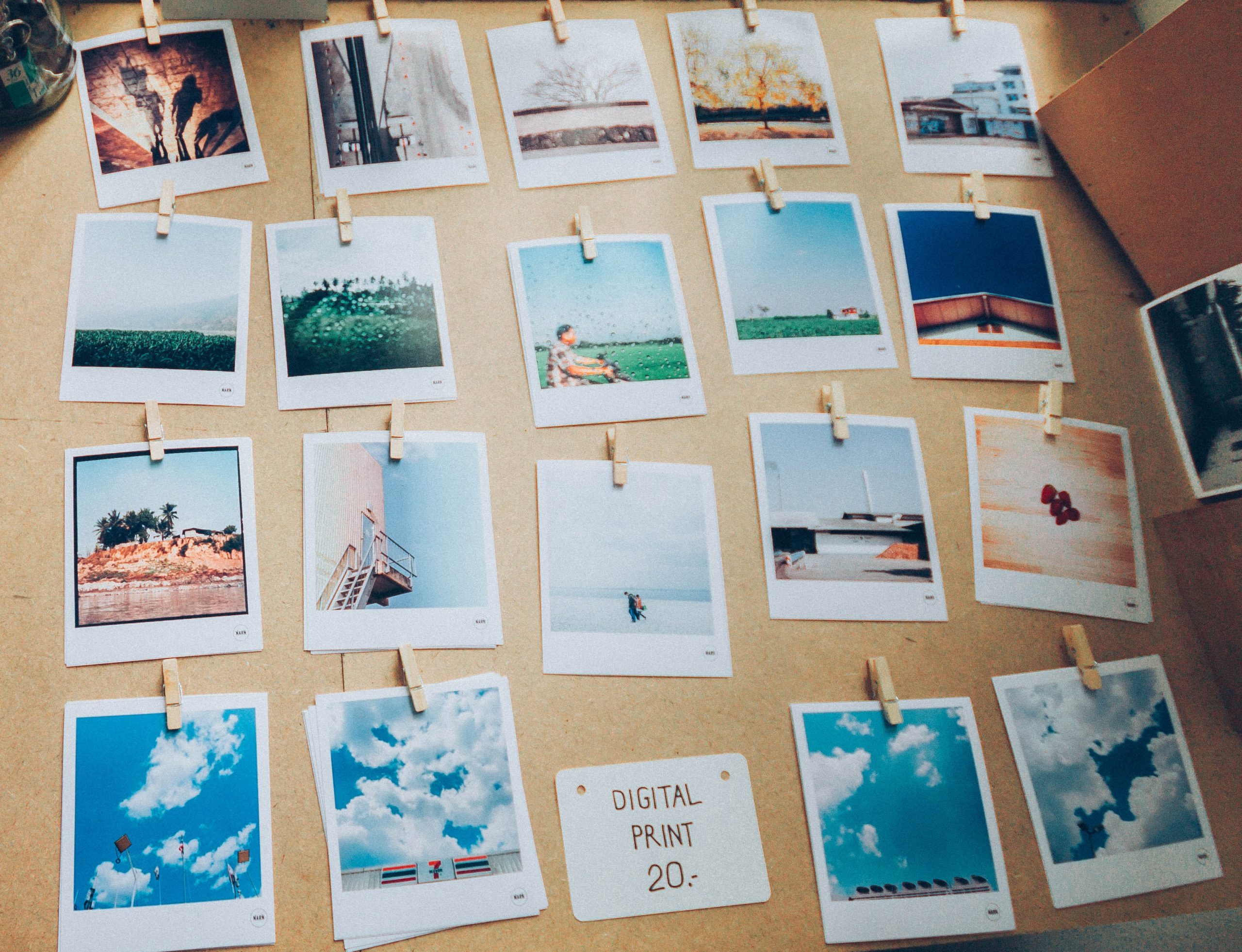 Photograph of a table on which some Polaroids depicting different subjects are arranged