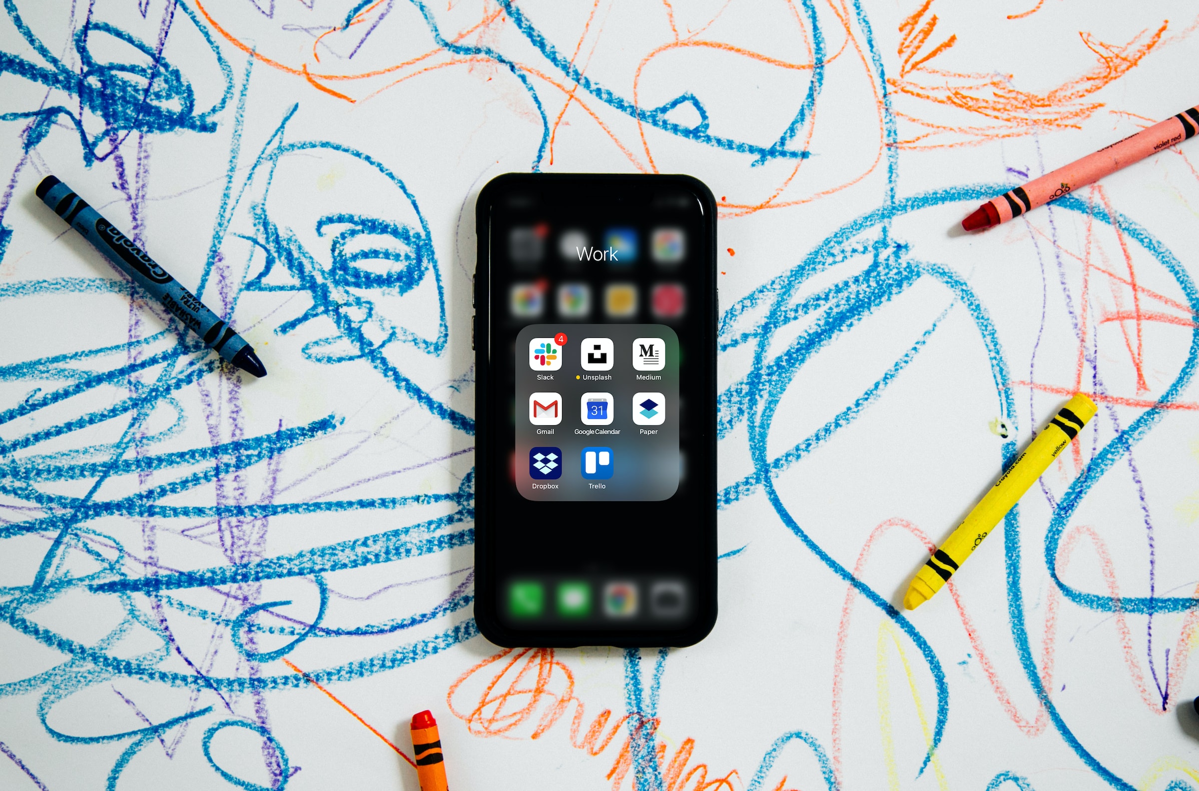 fotografia di uno smartphone su un foglio con scarabocchi di pastelli colorati
