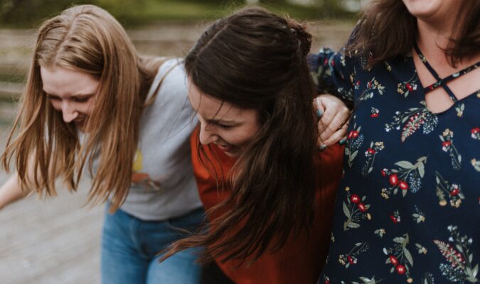 Fotografia di tre ragazze abbracciate che ridono