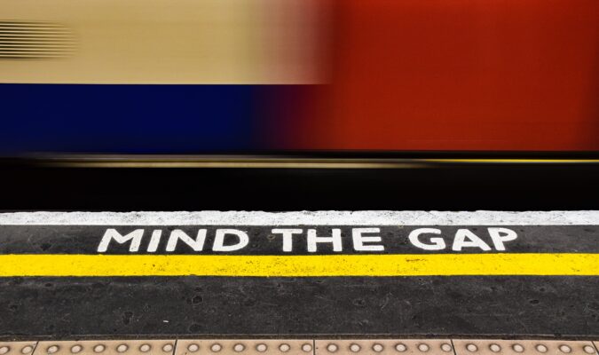 Foto di una banchina con scritta Mind the gap