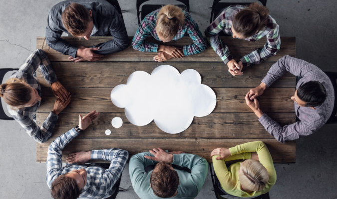 Photo of people around a desk, with a cartoon cloud